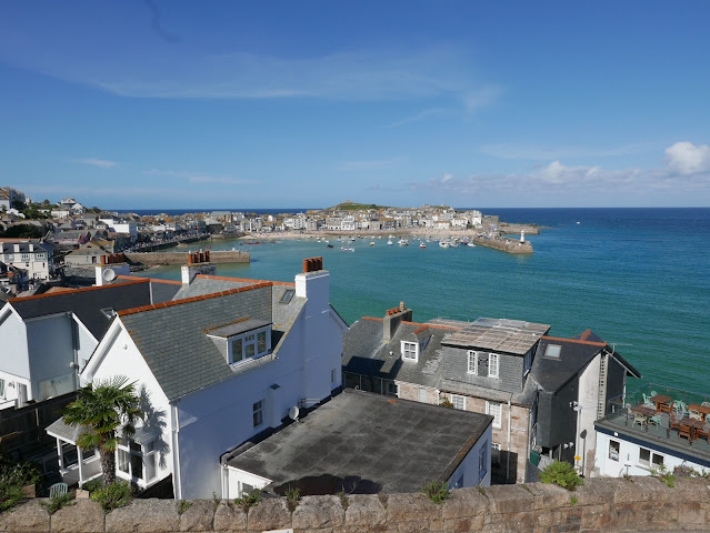 A view of St Ives harbour over the roofs of houses.