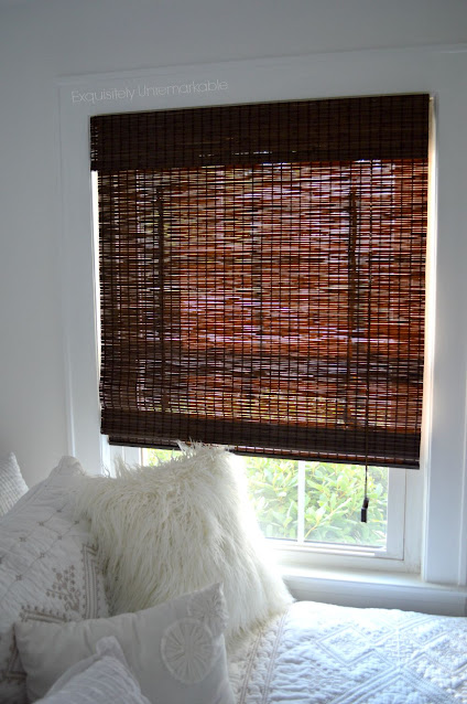 Brown roman shade on window in bedroom