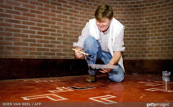 Dutch King Willem Alexander paints the floor in the sports area of a cultural centre in the village Tricht, on March 21, 2015. Members of the Dutch royal family take part in the national voluntary event NLdoet.