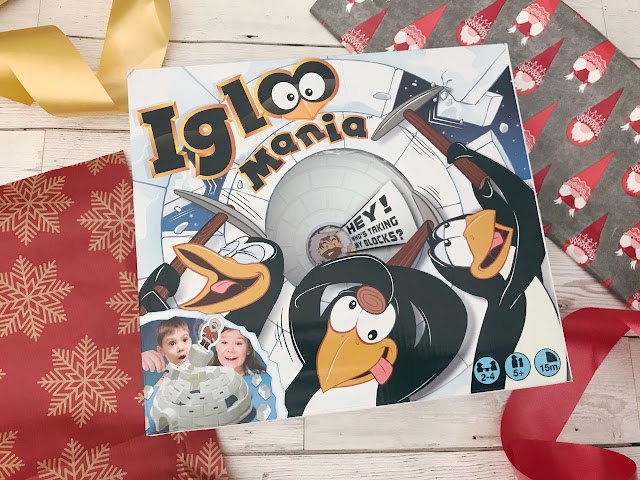 Picture of the Igloo Mania game in its box, surrounded by wrapping paper, ribbon