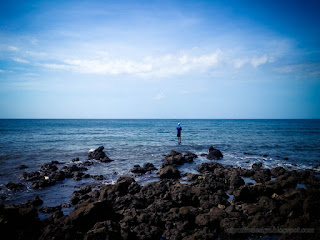 Fisherman Fishing In The Distance The Rocky Seashore At Umeanyar Village North Bali Indonesia