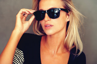 A girl is wearing black sunglasses