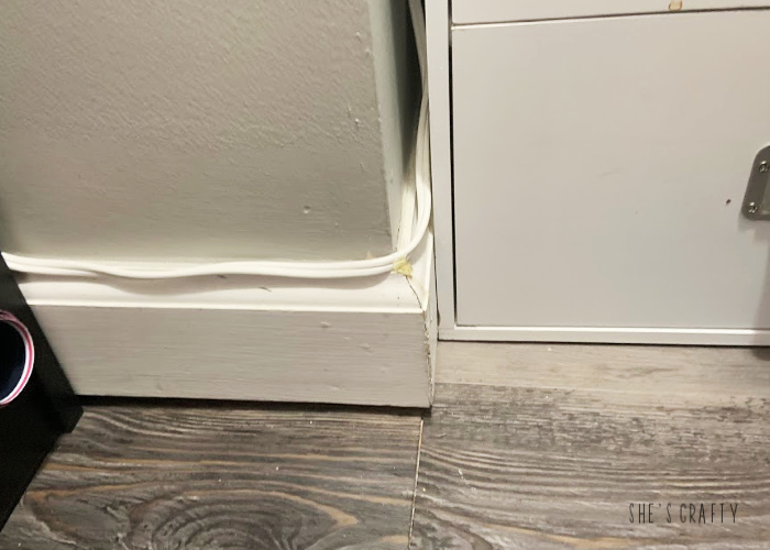 How to hide cords in a small craft room by attaching them to baseboards