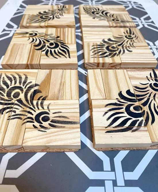rows of coasters with feathers stenciled on top