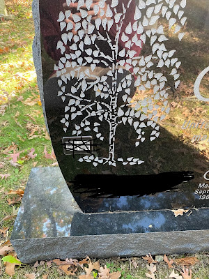 Gravestone with QR codes obscured for anonymization.
