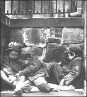 Two poor, homeless children sleeping in an alley