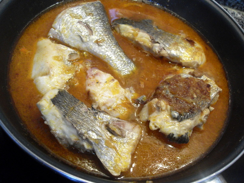 Cocinando las doradas con el caldo de pescado.
