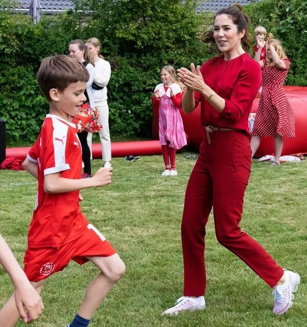 Crown Princess Mary wore a banora red gathered silk blouse from Hugo Boss, and ivory white cashmere coat from Boss. Denmark and Finland