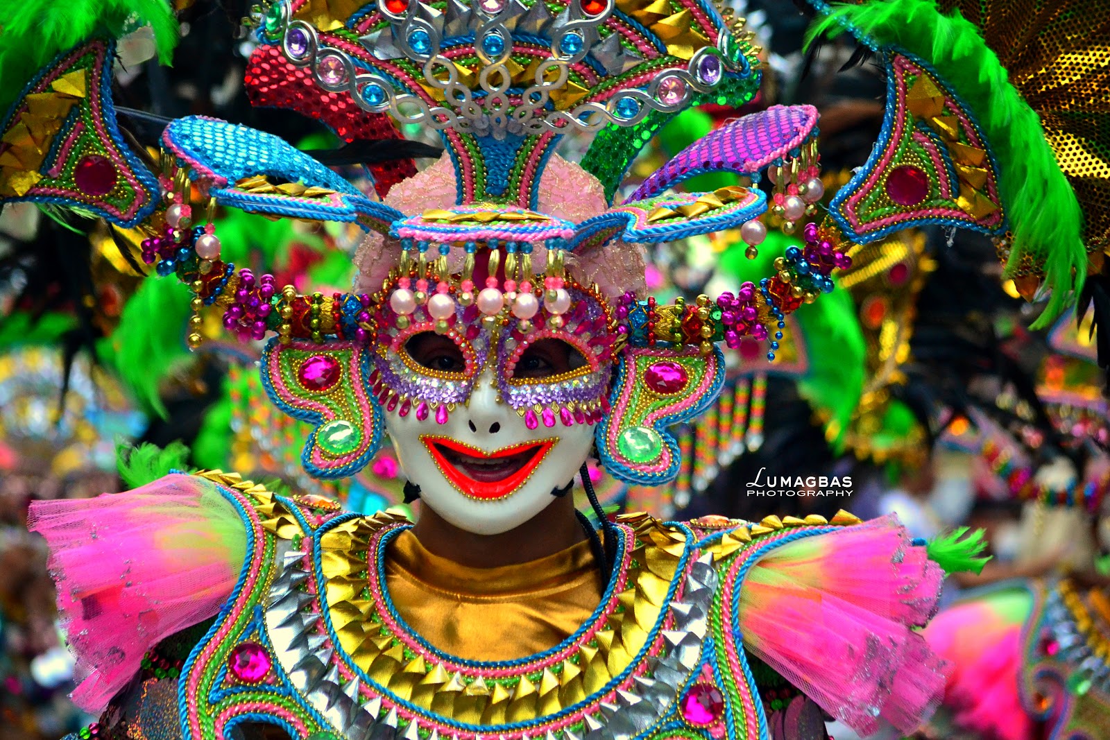  A colorful and intricate mask, adorned with beads, sequins, and feathers, is worn by a dancer during a traditional dance performance.