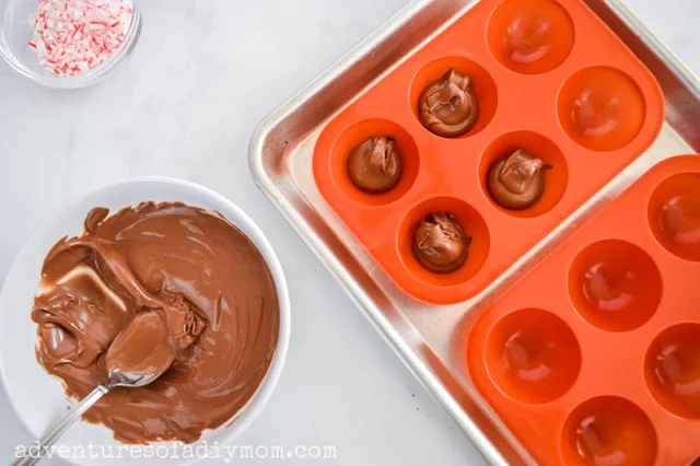 adding chocolate to round silicone molds