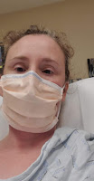 Head shot of Alynda wearing a hospital gown and a face mask