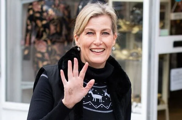 The Countess of Wessex wore a black reindeer-patterned jumper, gilet, and chic long skirt. Patrick Mavros pangolin earrings in sterling silver