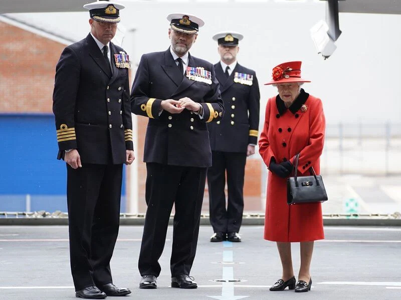 Queen Elizabeth wore a red coat, gold diamond brooch. HMS Queen Elizabeth and sister aircraft carrier HMS Prince of Wales