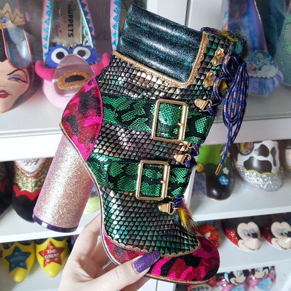 Irregular Choice Bobs Ur Uncle ankle boot held in hand in front of shoe shelves