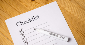 A checklist with some tick boxes and a pen