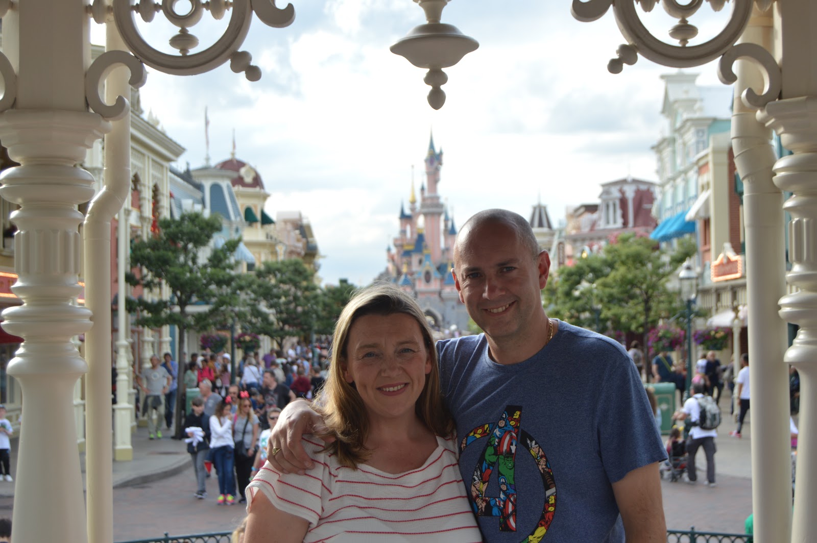 a couple standing in front of the disney castle 