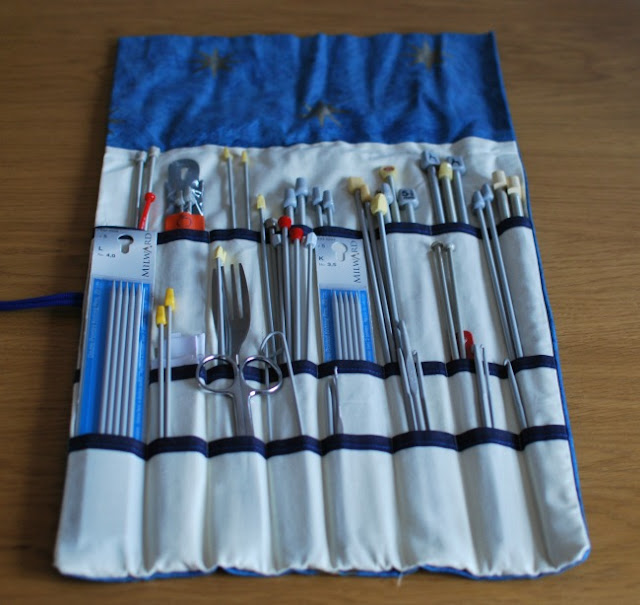 inside of filled knitting needle roll. cream lining and dark blue edging
