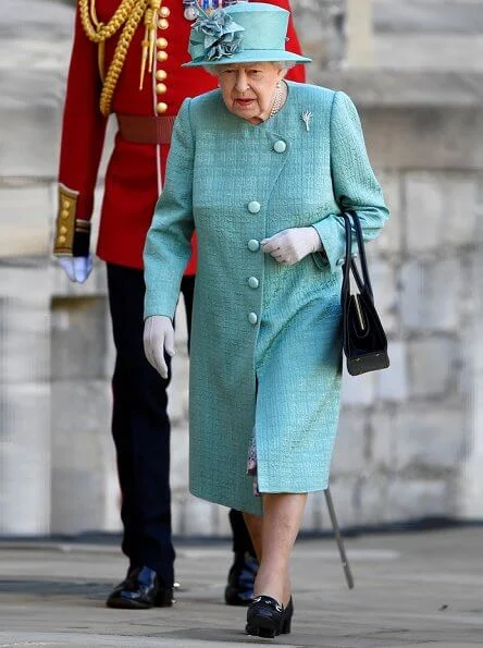 Queen is wearing a Stewart Parvin outfit, plus a floral silk dress with pleated hem detail, in shades of jade grey and dusty pink