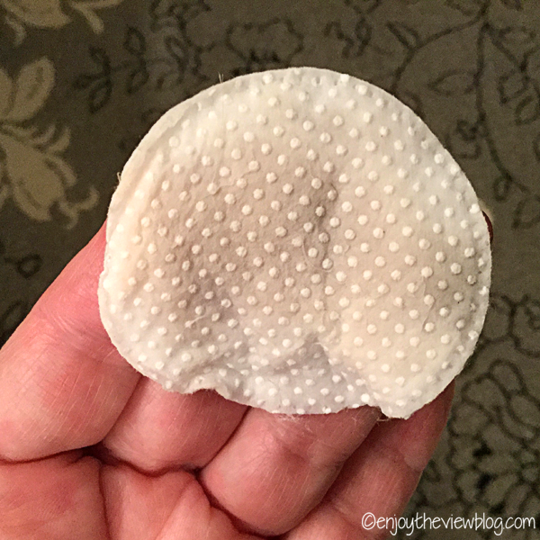 cotton exfoliating pad with makeup residue on it