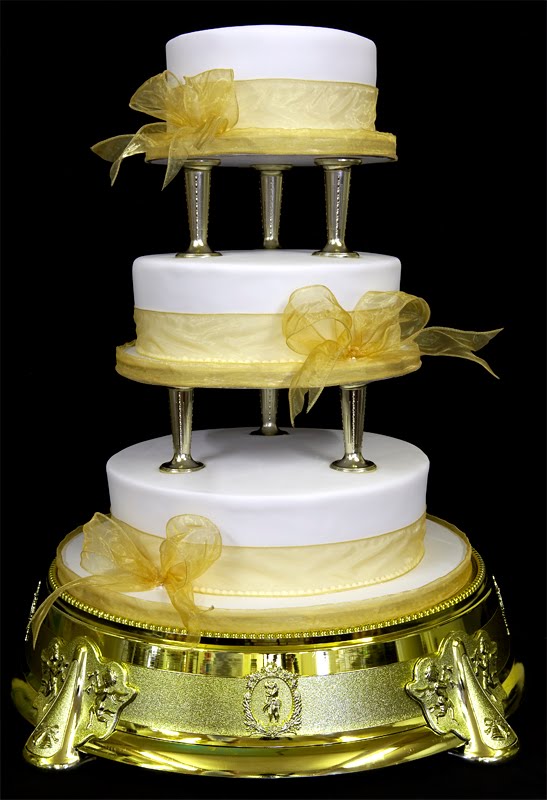  three tier wedding cakes separated by columns and with yellow accents