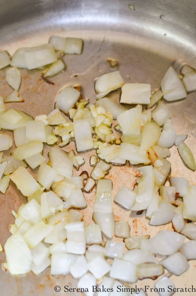 Onions and garlic caramelizing in a stainless steel soup pot.
