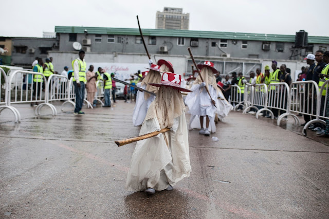 A young Eyo masquerader dances as he leads the group into the Tafawa Balewa Square in Lagos on May 20, 2017. The white-clad Eyo masquerades represent the spirits of the dead and are referred to in Yoruba as “agogoro Eyo. The origins of the Eyo Festival are found in the inner workings of the secret societies of Lagos where the masquerades ensure safe passage for the spirit of Kings and notable Chiefs into the afterlife. / AFP PHOTO / STEFAN HEUNIS