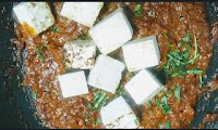 Pouring fried paneer into the gravy for paneer masala recipe