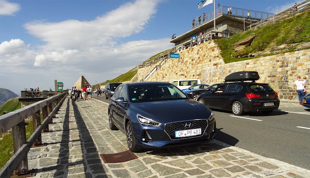 Blauer Hyundaii30 auf Pass Fuscher Törl, Touristen, Holzgeländer, Autos, 