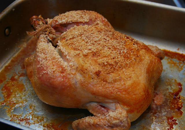 crispy brown roasted chicken in stainless steel roasting pan