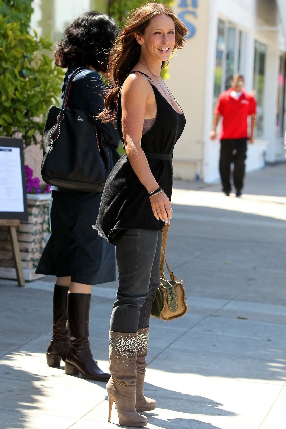 Woman wearing a black top, gray jeans and beige embellished boots