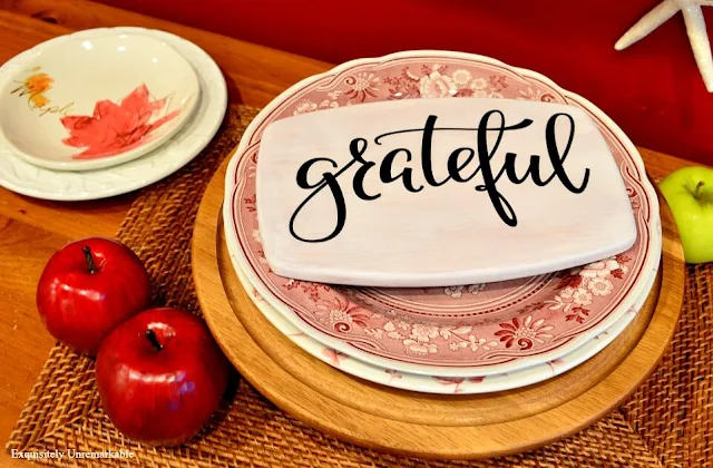 Grateful Sticker on white painted board on a cake plate with fall plates around it