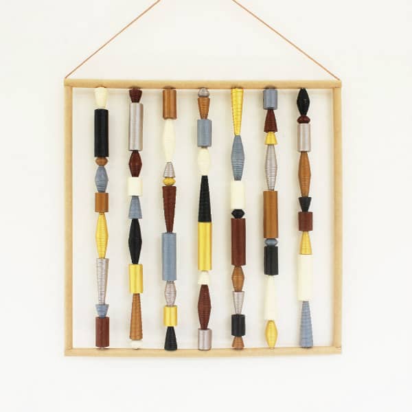 vierkante, eigentijdse muurkunst bestaande uit verticaal weergegeven lijnen van papierkralen in metaaltinten