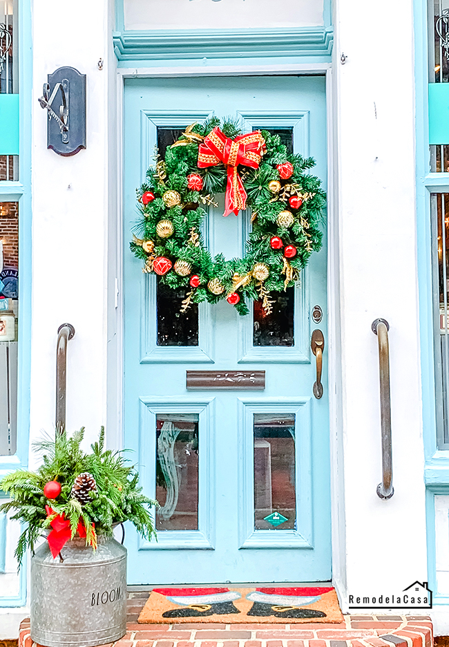 teal front door with holiday wreath on it.