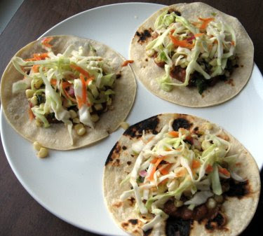 tacos with refried beans, corn with green onion, and curtido de repollo