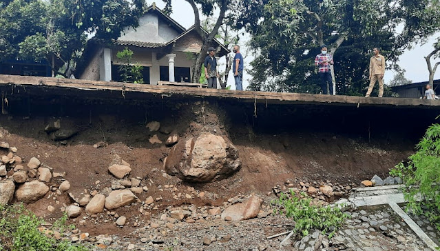 Mojokerto - Penahan jalan di Dusun Jembul Lor, Desa Manting, Kecamatan Jatirejo, Kabupaten Mojokerto ambrol. Ambrolnya penahan jalan sepanjang 50 meter dengan ketinggian 3 meter ini ambrol setelah diguyur hujan deras selama empat jam.  Kepala Pelaksana Badan Penanggulangan Bencana Daerah (BPBD) Kabupaten Mojokerto, Muhammad Zaini mengatakan, penahan jalan di Dusun Jembul Lor, Desa Manting, Kecamatan Jatirejo, Kabupaten Mojokerto ambrol pada, Minggu (31/10/2020) malam.  “Panahan jalan di Dusun Jembul Lor, Desa Manting, Kecamatan Jatirejo, Kabupaten Mojokerto ambrol pada Minggu malam sekira pukul 22.00 WIB. Sebelumnya, pada siang harinya sekira pukul 14.00 WIB hujan deras terjadi di sejumlah wilayah Kabupaten Mojokerto,” jelasnya, Selasa (3/11/2020).  Masih kata Zaini, tak terkecuali di wilayah Kecamatan Jatirejo, Kabupaten Mojokerto. Hujan deras turun di wilayah Jatirejo terjadi hampir empat jam lamanya. Mulai pukul 14.00 WIB hingga pukul 18.00 WIB. Akibat hujan deras dengan intensitas lama tersebut menyebabkan debit Sungai Manting tak bisa menahan air.  “Debit air di Sungai Manting mengalami peningkatan sehingga tak mampu menahan lagi. Akibatnya, air di Sungai Manting meluber ke jalan dan menggerus tanah penahan jalan. Penahan jalan sepanjang 50 meter dengan ketinggian 3 meter akhirnya ambrol,” ujarnya.  Saat ini, lanjut Zaini, jalan di Dusun Jembul Lor, Desa Manting, Kecamatan Jatirejo, Kabupaten Mojokerto hanya bisa dilewati kendaraan satu arah dengan tanpa muatan. Upaya yang dilakukan saat ini yakni membuat pembatasan akses jalan menuju Desa Manting dan BPBD juga berkoordinasi dengan Dinas Pekerjaan Umum dan Perumahan Rakyat (PUPR) untuk tindak lanjut. (Jay)