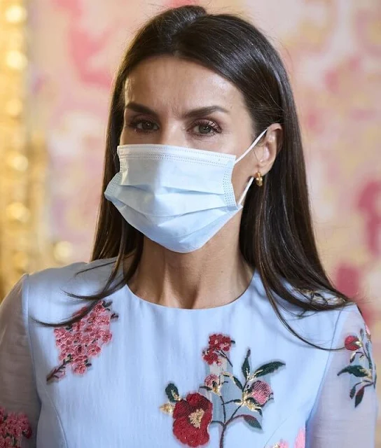 Queen Letizia wore an embroidered blue dress from the Resort 2018 Collection of Carolina Herrera. Magrit pink clutch and pink suede pumps