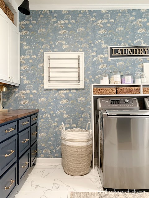 laundry room with floral wallpaper and hanging drying rack