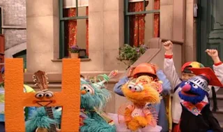 The letter H tells Zoe, Rosita and Grover that each of them is a real hero. Sesame Street Episode 4071, Professor Super Grover's School for Superheroes