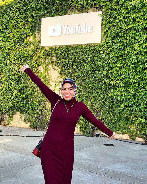 Beyza posing in front of YouTube sign at her office.