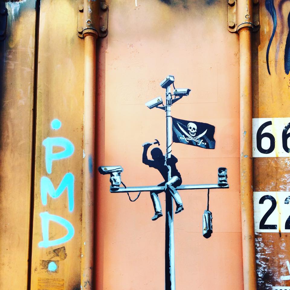 graffiti of cctv cameras and private flag on orange container
