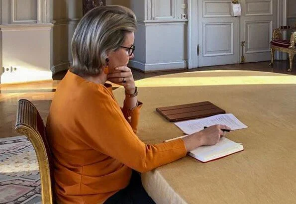 Queen Mathilde is honorary president of Unicef Belgium. Queen Mathilde wore a new orange silk blouse top from Natan, and orange earrings