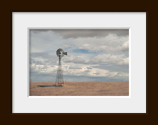 A western prairie photo of a windmill on the high plains of Colorado surrounded by grasslands. Pawnee National Grassland, Colorado