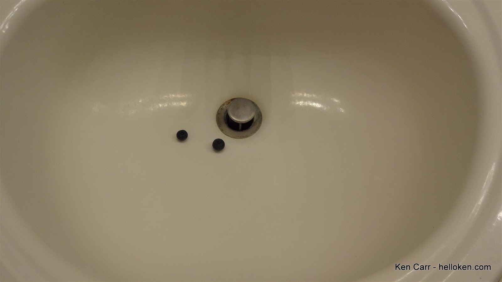 Two blueberries in a bathroom sink