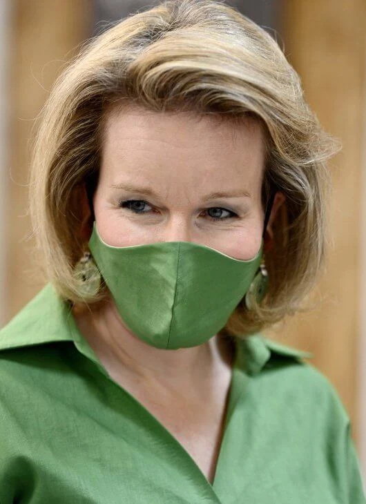 Queen Mathilde wore a green belted shirt dress from Natan, and she carries Fabienne Delvigne cluth bag