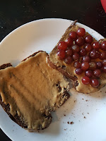2 slices of toast, one with peanut butter, and one with grapes
