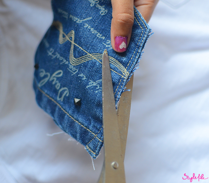 Woman's fingers with nail art cutting around denim patch pocket for the DIY tutorial of the Denim Pocket Patch