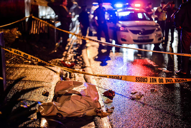 The body of a suspected drug dealer lies in a Manila street