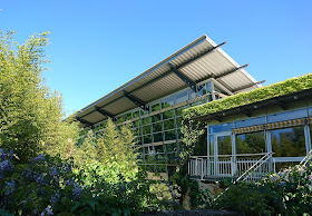 Sportbad Heidberg. Glasfront des Sportbad-Teils mit emporstrebendem Dach.