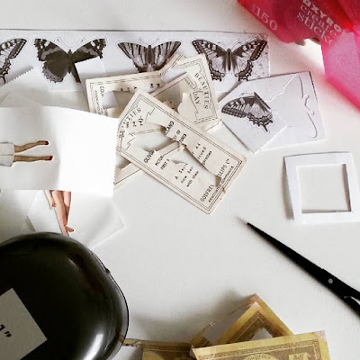 Various bits of paper on a desk, along with a pair of scissors, a paper punch and a sticker machine.