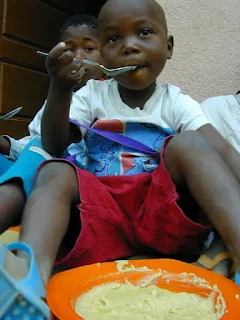 Rui eating funge with his family in Huambo Angola.